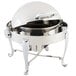 A Bon Chef stainless steel chafer with a roll top lid on a stand with Roman legs and chrome accents.