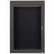 An Aarco bronze anodized aluminum cabinet with a black letter board and glass door with key lock.