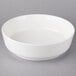 A white Villeroy & Boch porcelain salad bowl on a gray surface.