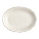 An ivory stoneware oval platter with a scalloped edge.