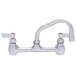 A silver Fisher wall mount faucet with lever handles and a swing nozzle.