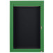 A green cabinet with a black board and door.