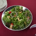 An American Metalcraft hammered stainless steel bowl filled with a salad on a table.