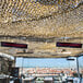 A Bromic Heating black outdoor patio heater on a rooftop with a large screen.