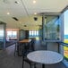 A room with a table and Bromic Heating black electric patio heater above a chair.