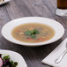 A bowl of soup in a Villeroy & Boch white porcelain deep plate on a table.