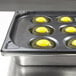 eggs in a pan with a black tray
