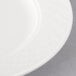 A close-up of a white Villeroy & Boch Bella porcelain plate with a circular design.