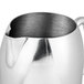 A Vollrath stainless steel water pitcher with a handle.