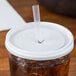 A Cambro translucent lid on a cup with a plastic straw.