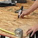 A hand using a Sharpie King Size black chisel tip marker to write on a table.