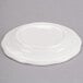 A CAC ivory china plate with a scalloped edge on a gray surface.