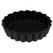 A close-up of a black fluted Matfer Bourgeat tartlet pan.