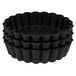 A stack of black Matfer Bourgeat fluted tartlet molds.