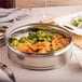 A Town stainless steel dim sum steamer with food inside on a table.