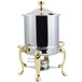 A Bon Chef stainless steel marmite chafer with brass accents on a counter.