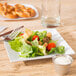 a fork on a plate with lettuce and tomato