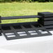 A black rectangular wood display with a shelf on top with square holes.