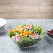 A salad in a clear acrylic bowl.