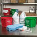 A green Noble Chemical bucket with white text on it, filled with a white jug and green container, on a kitchen counter.