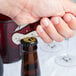 A person using a Pullparrot Waiter's Corkscrew with a burgundy handle to open a bottle on a table in a winery cellar.
