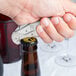A hand using a Pullparrot waiter's corkscrew to open a bottle on a table.