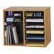 A Safco oak wood file organizer with 12 sections holding papers and pens.