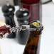 A person using a Franmara Tavern Wing Corkscrew with a burgundy body to open a bottle of wine.