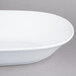 An American Metalcraft white melamine serving bowl with a white rim on a gray surface.