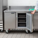 A person opening a Beverage-Air stainless steel worktop refrigerator.