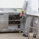 A man in a white coat opening a Beverage-Air worktop refrigerator.