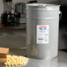 A white bucket labeled "LouAna Classic Blend Popping Oil" on a counter.
