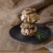 A stack of cookie ice cream sandwiches on a GET Black Matte melamine plate.