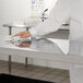 Regency stainless steel wire shelving with solid shelves being cleaned in a kitchen.