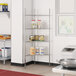 A Regency chrome wire shelf kit in a kitchen with food containers on the shelves.