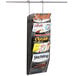 A Safco black Onyx mesh wall mount magazine rack holding four magazines.
