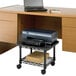 A Safco black printer stand with a printer on the bottom shelf and a laptop on top.