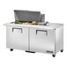 A True refrigerated sandwich prep table with large salad bowls on a counter.