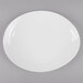 A white oval melamine platter with a textured rim on a gray surface.