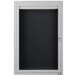 A white cabinet with a black door with a black letter board inside.