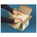 A person's hands opening a box of Quality Park white business envelopes.