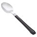 A WNA Comet Reflections Duet stainless steel look teaspoon with a black handle.