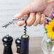 A person using a Franmara Duo-Lever corkscrew to open a bottle of wine.