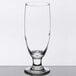 A close up of a Libbey stemmed pilsner glass with a small rim on top.