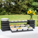 A Vollrath Cubic wood display with a white bowl of macaroni and cheese on a buffet table.