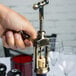 A hand opening a Franmara vintage style corkscrew over a table.