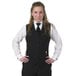 A woman wearing a Henry Segal black server vest and tie over a white shirt.