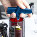 A person holding a Franmara dark blue plastic corkscrew and bottle opener.