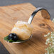 A Bon Chef stainless steel spoon with food on it.