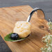 A Bon Chef Reflections spoon with dessert on it.